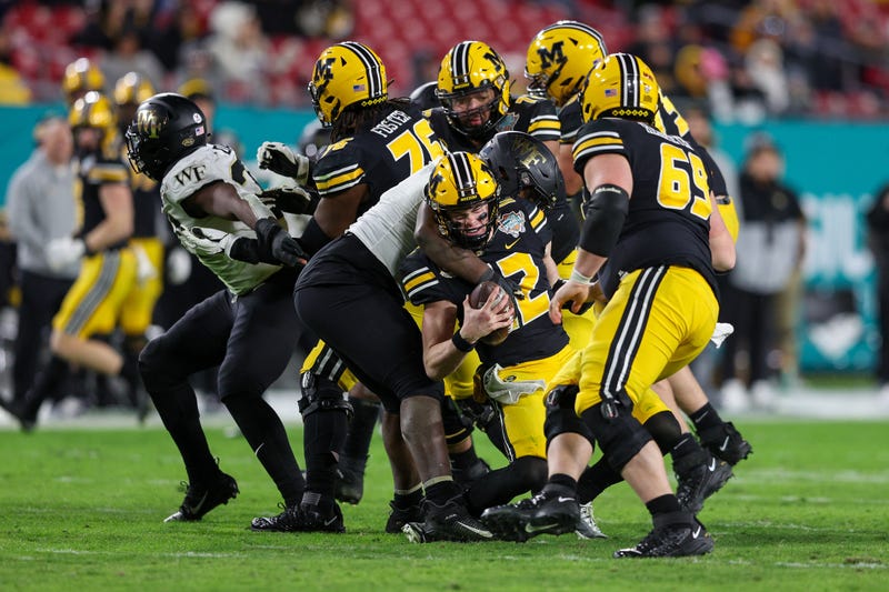 Missouri Tigers quarterback Brady Cook (12) is sacked by Wake Forest Demon Deacons defensive lineman Kobie Turner (0) in the fourth quarter in the 2022 Gasparilla Bowl at Raymond James Stadium.