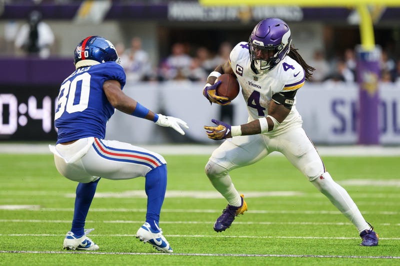 Minnesota Vikings running back Dalvin Cook (4) runs after a catch while New York Giants cornerback Darnay Holmes (30) defends during the third quarter at U.S. Bank Stadium.