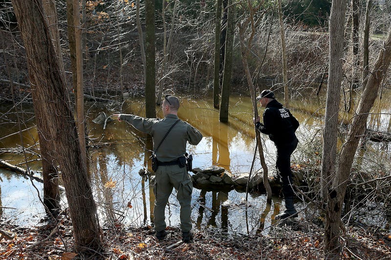 An Massachusetts environmental police officer points out something to a state trooper during their search for Ana Walshe across the street from her home on Rt. 3A in Cohasset on Saturday, Jan. 7, 2023. Cohasset Ana Walshe Missing Person K9 Mass State Police Husband Art Fraud Andy Warhol