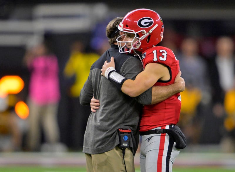 Georgia Bulldogs quarterback Stetson Bennett (13) is greeted by head coach Kirby Smart as he comes out of the game in the 4th quarter against the TCU Horned Frogs in the CFP national championship game at SoFi Stadium.