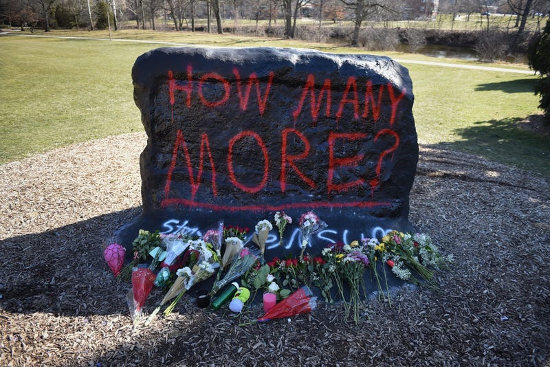 Flowers seen at the base of \"The Rock\" on the campus of Michigan State University, Tuesday, Feb. 14, 2023, to honor the victims of Monday's shooting on campus.