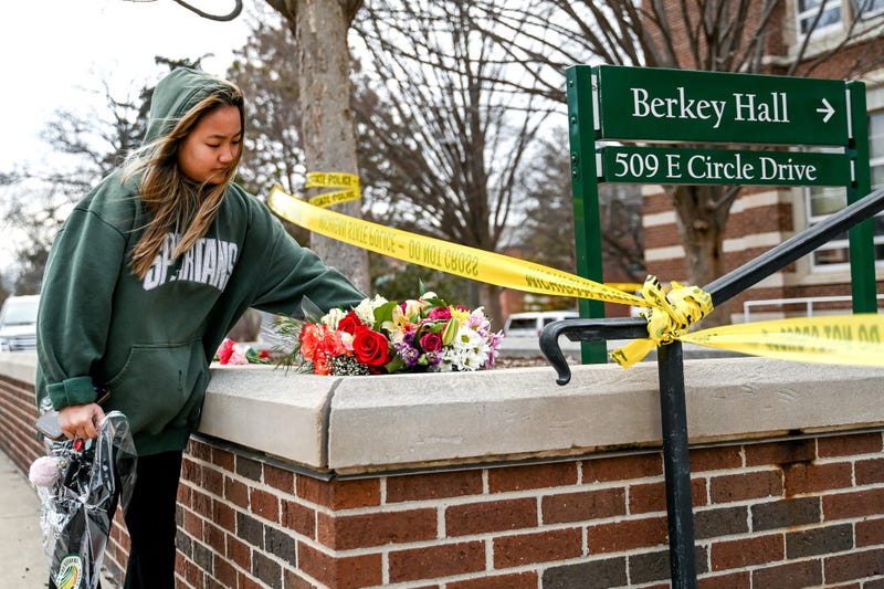 Michigan State University senior Ashley Le places flowers outside Berkey Hall