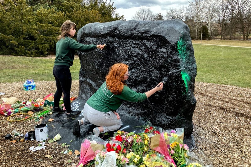Michigan State students Rylee Warner and Katrina Groeller cover The Rock at MSU with black paint erasing the message \"Allow us to defend ourselves, carry on campus,\" on Wednesday, Feb. 15, 2023, on campus in East Lansing.
