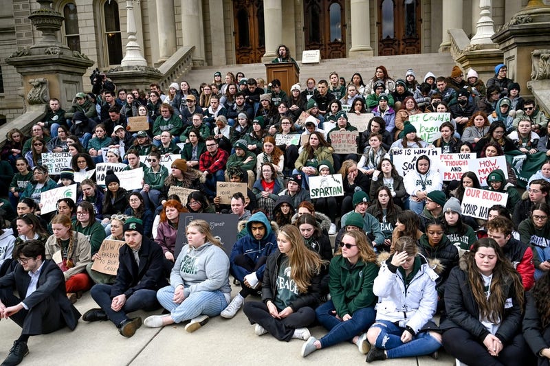 Michigan State University students gather on the front steps of the Capitol
