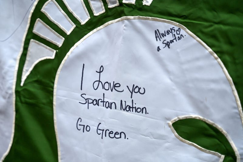 A message of support for the Michigan State community is written on a Spartans flag fixed to a fence outside the MSU Union on Thursday, Feb. 16, 2023, in East Lansing.
