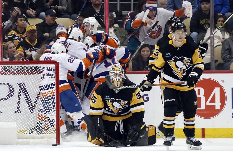 Islanders celebrate a win with Tristan Jarry slumped