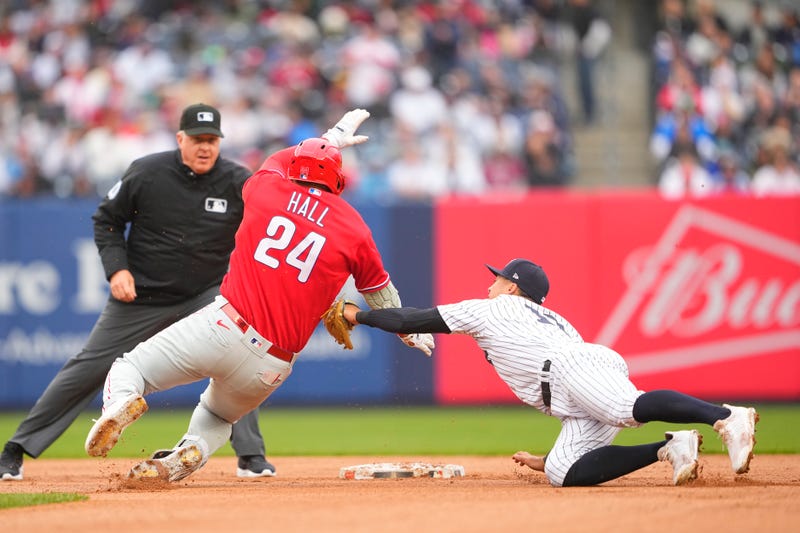 New York Yankees shortstop Anthony Volpe (11) tags out Philadelphia Phillies first baseman Darick Hall (24) trying to stretch a single into a double during the fourth inning at Yankee Stadium.