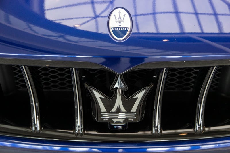 close up of a maserati logo on blue vehicle
