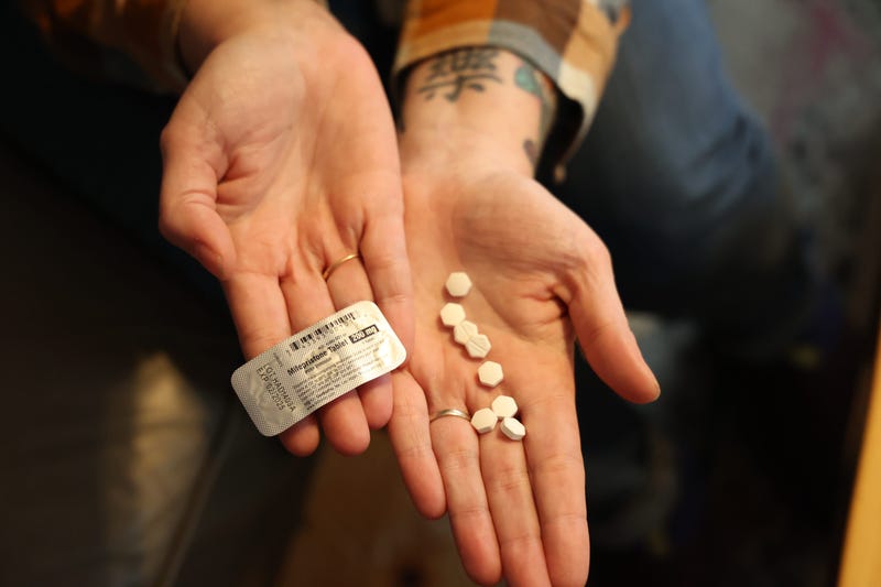 An abortion-rights advocate holds abortion pills.