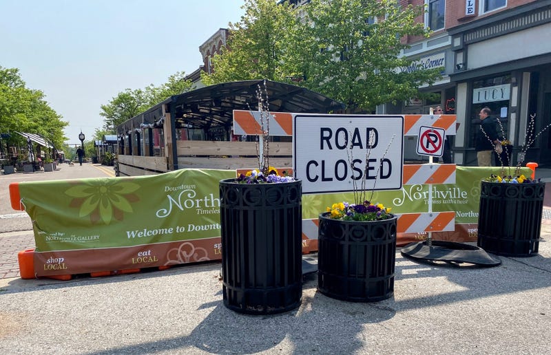 A road closed barrier blocks off a street for outdoor dining