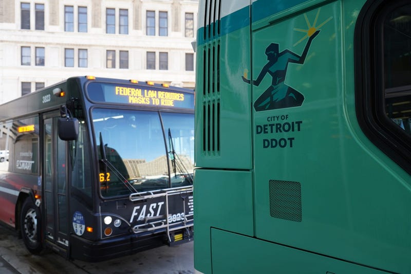 A City of Detroit DDOT bus and a Smart bus are parked at the Rosa Parks Transit Center in downtown Detroit