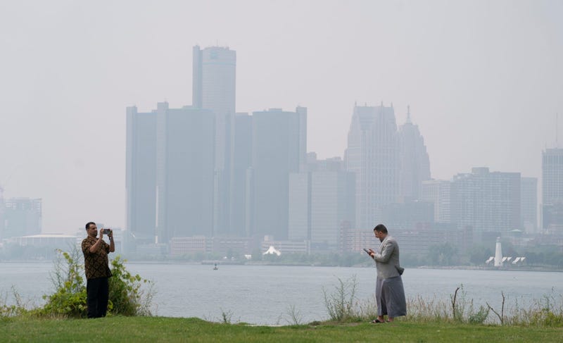 Faras Altareb of Chattanooga, left, takes photos at left as Saddam Ali from California looks at photos on Belle Isle as they celebrate Eid with family from Hamtramck on Wednesday, June 28, 2023. Heavy smoke filtered into Detroit after wildfires from Canada.