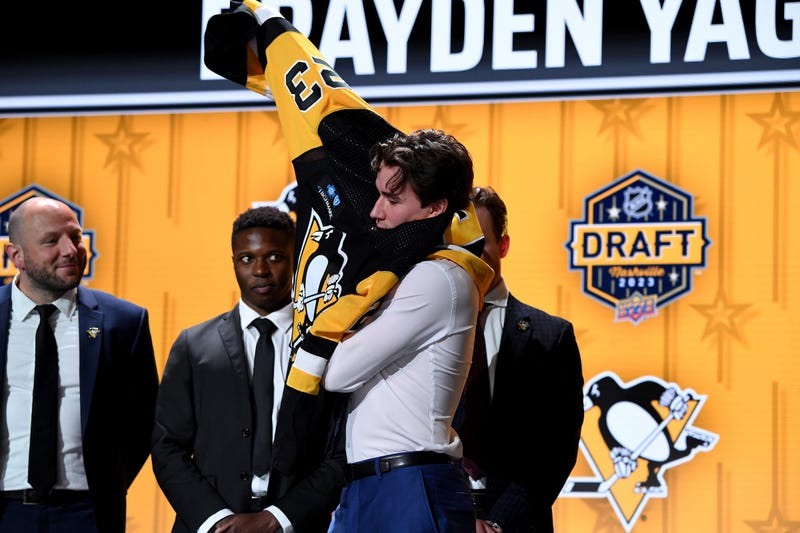 Brayden Yager putting on Pens jersey at draft