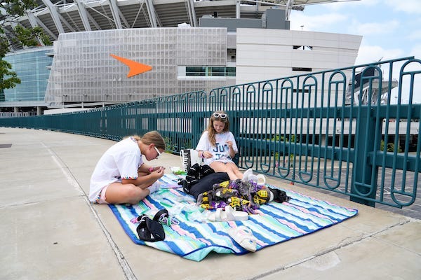 Aubrey Ayers, left, and Madalyn Davidson, both of Cincinnati, make friendship bracelets on their blanket they set up to watch the Taylor Swift the Eras Tour concert from on Friday, June 30, 2023, outside Paycor Stadium in Cincinnati