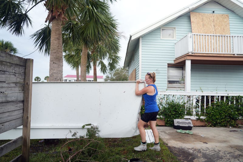 Megan Snow cleans up debris around her house in the Keaton Beach area of Perry, Fla. on Thursday, Aug. 31, 2023 the day after Hurricane Idalia made landfall