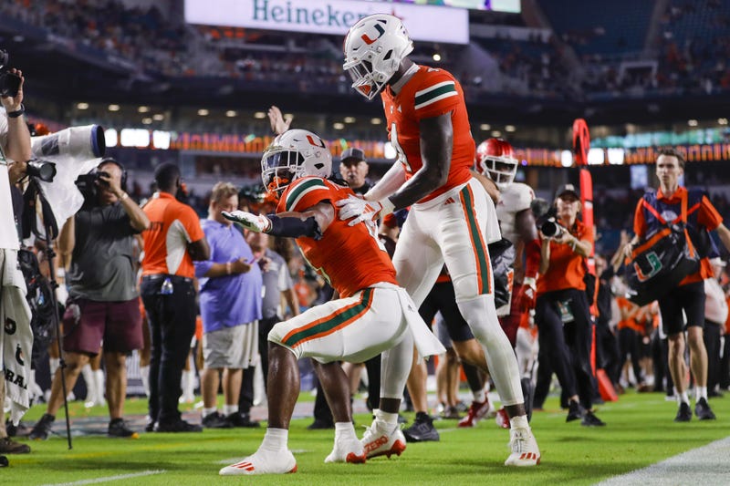 Miami Hurricanes running back Henry Parrish Jr. (21) celebrates with wide receiver Colbie Young (4) after scoring a touchdown against the Miami (OH) Redhawks during the fourth quarter at Hard Rock Stadium