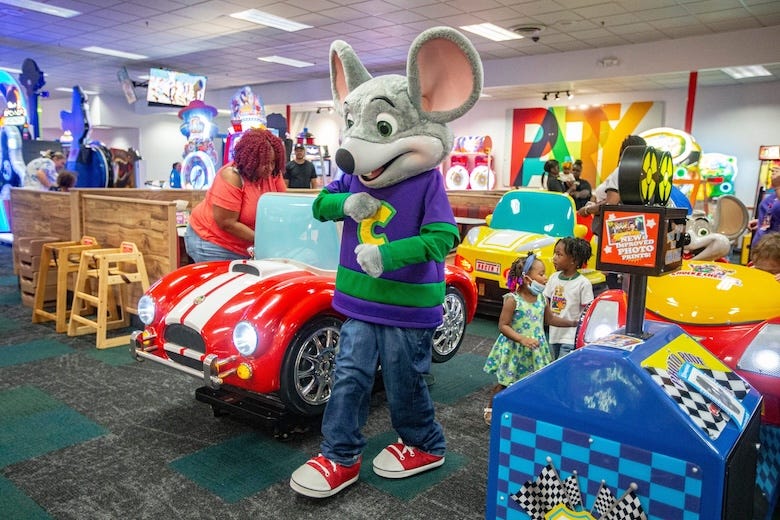 Chuck E. Cheese greets children in the arcade