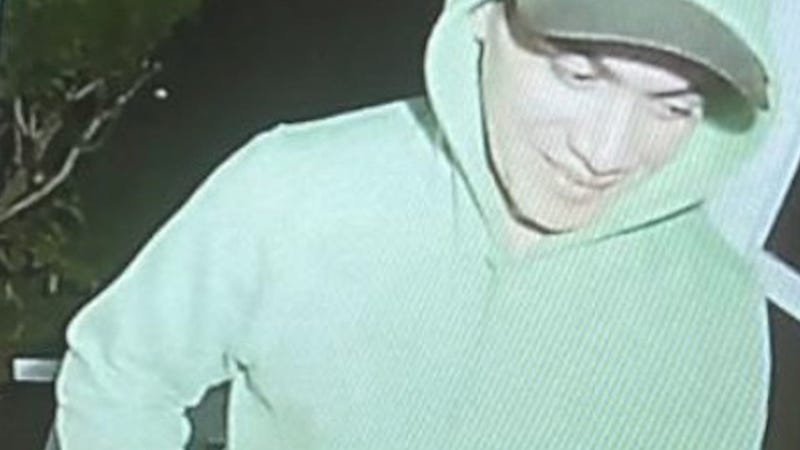 Escaped inmate Danelo Cavalcante seen on a former coworker's doorbell camera, clean shaven wearing a bright green hoodie, blue jeans, and white sneakers.