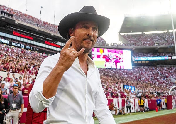 Actor Matthew McConaughey holds up the sign of the horns as he walks onto the field for the Texas Longhorns game against Alabama at Bryant-Denny Stadium in Tuscaloosa, Alabama