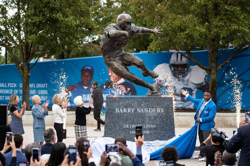 Barry Sanders, right, along with Detroit Lions owner and chair emeritus Martha Ford and principal owner and chair Shiela Ford Hamp unveil the statue outside of Ford Field in Detroit on Saturday, Sept. 16, 2023.