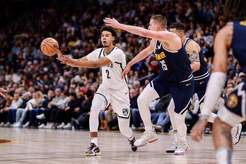 Brooklyn Nets forward Cam Johnson (2) passes the ball as Denver Nuggets center Nikola Jokic (15) guards during a game last season.