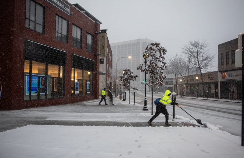 Workers clear the sidewalk of snow in downtown White Plains on Feb. 13, 2024