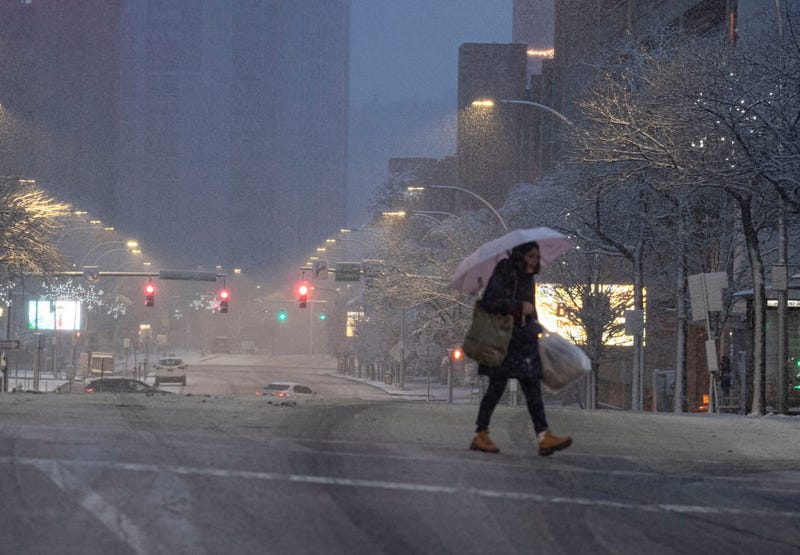 A pedestrian walk through snow in downtown White Plains at dawn Feb. 13, 2024