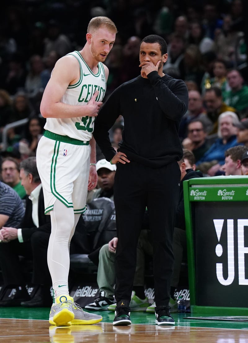 Boston Celtics head coach Joe Mazzulla talks with forward Sam Hauser (30) from the sideline at they take on the Brooklyn Nets at TD Garden.