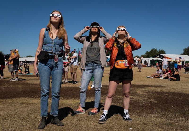 From left, Chloe Haynes, Jatzin Alvarado, and Emma Gorski watch the annular solar eclipse at Zilker Park on Oct. 14, 2023, during the Austin City Limits Music Festival.