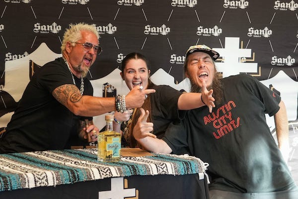 Guy Fieri taking a photo in support of his and Sammy Hagar’s Santo Spirits brand