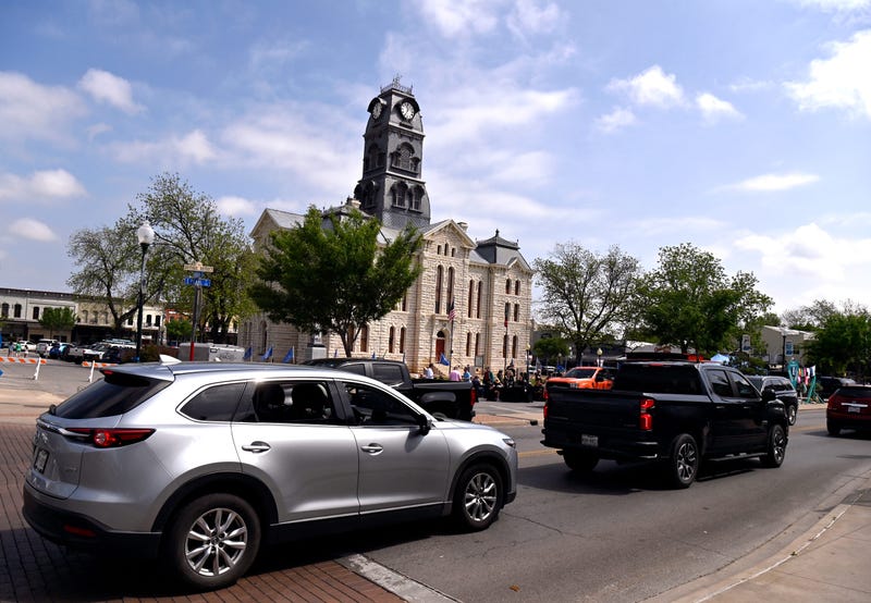 Cars begin to crowd the square around the Hood County Courthouse in Granbury, Texas about two hours before the total solar eclipse Monday, April 8, 2024. Crowds may have been lighter than expected due to predictions of cloudy weather which did abate in the hours before the event.