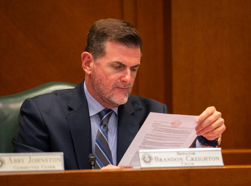 Senator Brandon Creighton, R - Conroe, reads material from a speaker during the public comment section of a Senate Education Committee meeting at the Texas State Capitol, on Tuesday, May 14, 2024.
