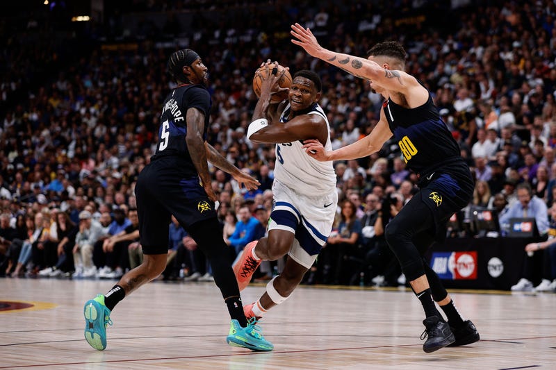 Timberwolves guard Anthony Edwards (5) drives to the basket against Denver Nuggets guard Kentavious Caldwell-Pope (5) and forward Michael Porter Jr. (1) in the first quarter during game five of the second round for the 2024 NBA playoffs at Ball Arena. 