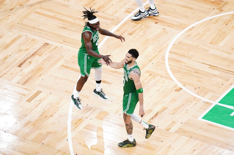 Boston Celtics forward Jayson Tatum (0) reacts with guard Jrue Holiday (4) in the fourth quarter against the Dallas Mavericks during game five of the 2024 NBA Finals at TD Garden.