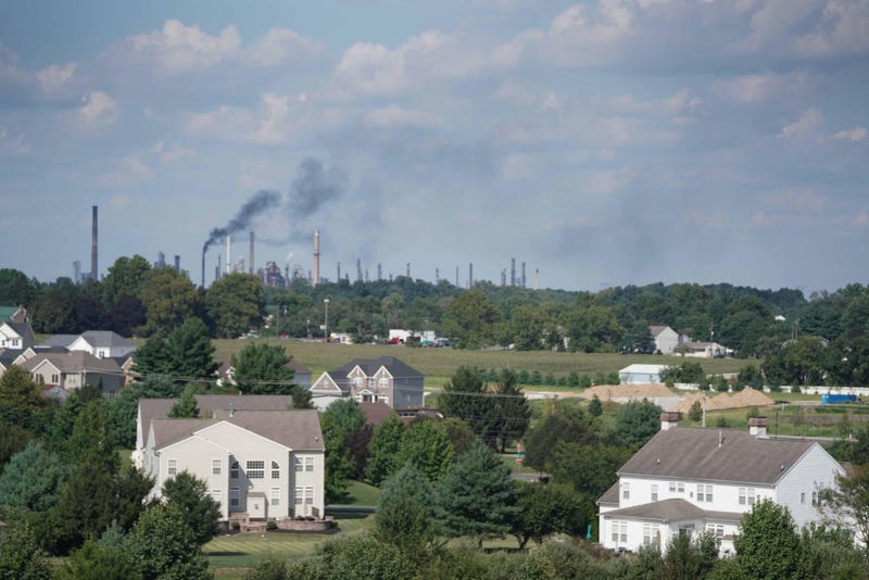 The Delaware City Refinery emits black smoke into the air in the distance over a residential neighborhood in New Castle, Delaware.