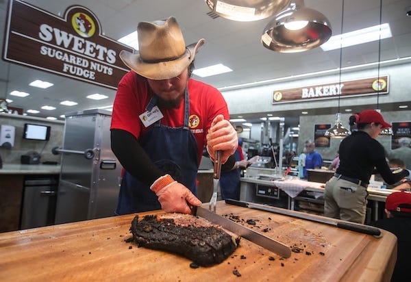 Buc-ee's employee slices fresh brisket on the board