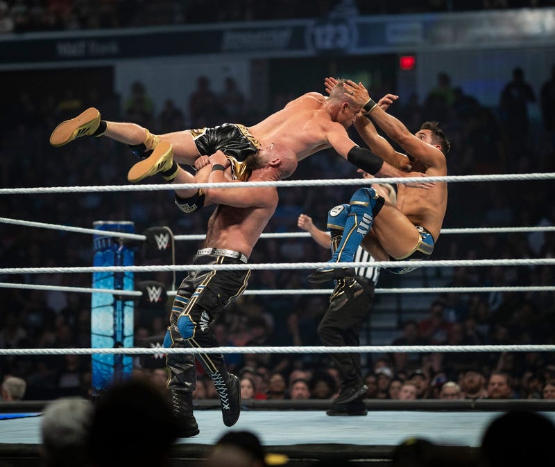 WWE superstar Tomasso Ciampa, left, and tag team partner Johnny Gargano perform the Shatter Machine on Grayson Waller.