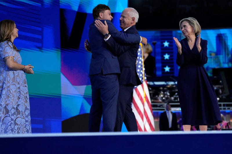 Vice Presidential nominee Tim Walz hugs son Gus Walz during the third day of the Democratic National Convention at the United Center. Hope Walz is at left, Gwen Walz at right.