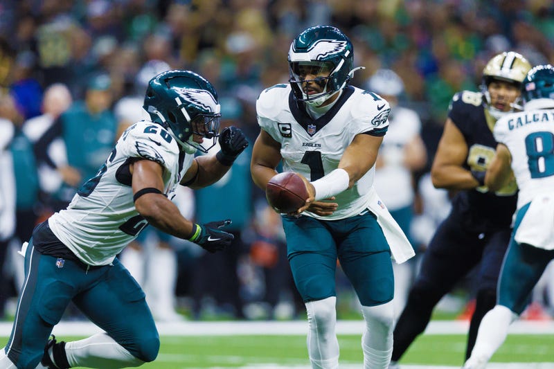 Philadelphia Eagles quarterback Jalen Hurts hands off to running back Saquon Barkley in a game against the New Orleans Saints on Sunday.