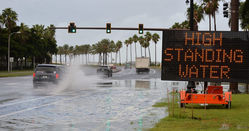 A sign warns motorists Thursday morning on the John Ringling Causeway at Sunset Drive in Sarasota as storm surge water from Hurricane Helene covers some of the traffic lanes