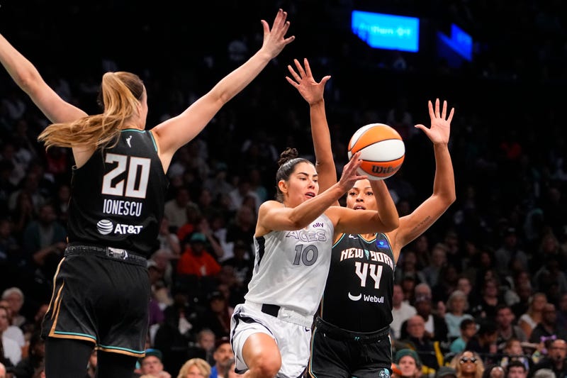 Las Vegas Aces guard Kelsey Plum (10) passes the ball against New York Liberty guard Sabrina Ionescu (20) and New York Liberty forward Betnijah Laney-Hamilton (44) during game one of the 2024 WNBA Semi-finals at Barclays Center.