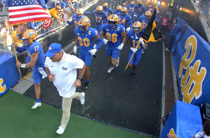 Pat Narduzzi and Pitt running on the field at Acrisure Stadium