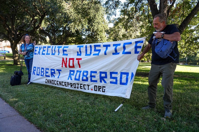 Amy Hedtke, left, and Bob Smilie, right, protest the execution of Robert Roberson ahead of a hearing with the Texas House of Representatives Committee on Judiciary and Civil Jurisprudence