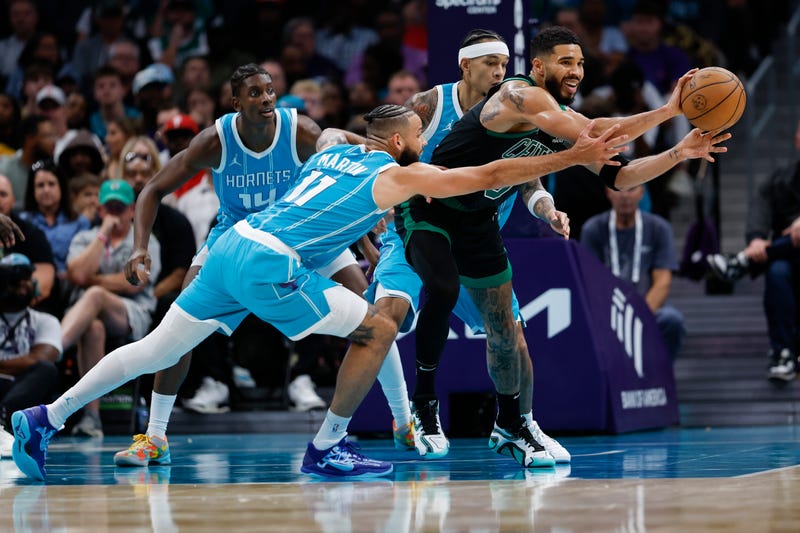 Boston Celtics forward Jayson Tatum (0) passes the ball while defended by Charlotte Hornets forward Cody Martin (11) during the second half at Spectrum Center.