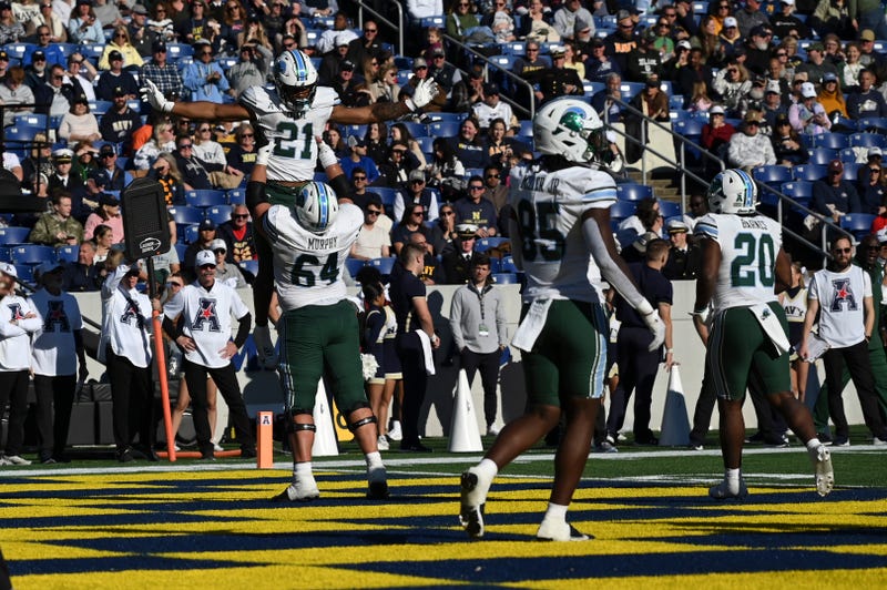 Nov 16, 2024; Annapolis, Maryland, USA; Tulane Green Wave running back Makhi Hughes (21) celebrates with center Brent Self (65) after scoring a touchdown during the second half against the Navy Midshipmen at Navy-Marine Corps Memorial Stadium.