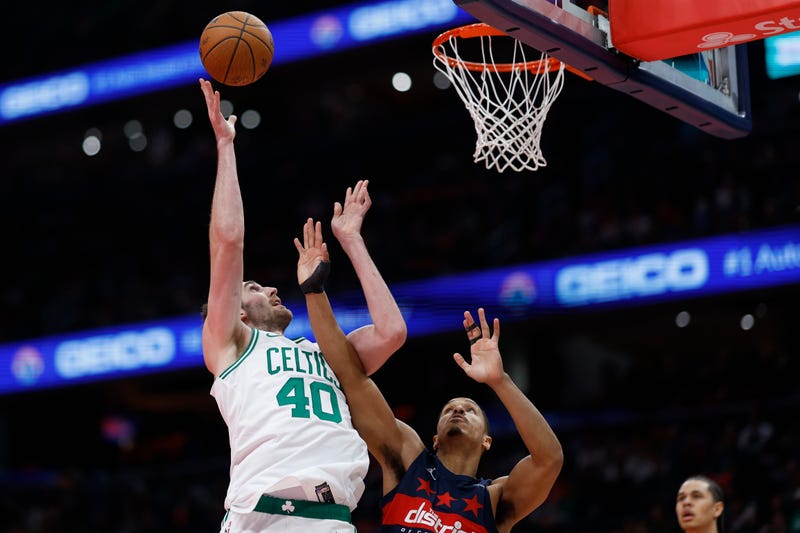 Washington, District of Columbia, USA; Boston Celtics center Luke Kornet (40) shoots the ball as Washington Wizards guard Malcolm Brogdon (15) defends in the first half at Capital One Arena.