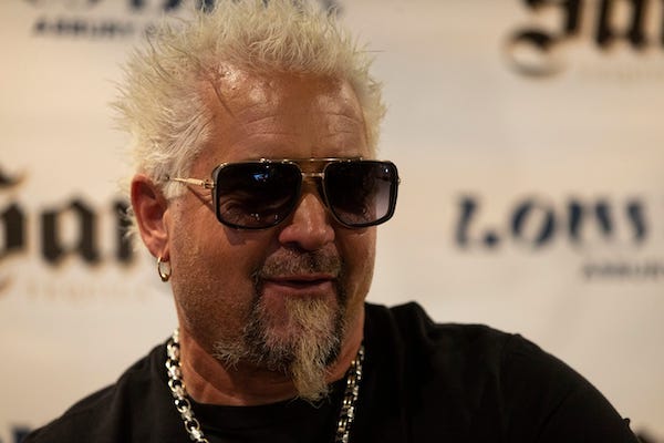 Celebrity chef and television host Guy Fieri visits Low Dive signing bottles of his tequila company, Santo Spirits