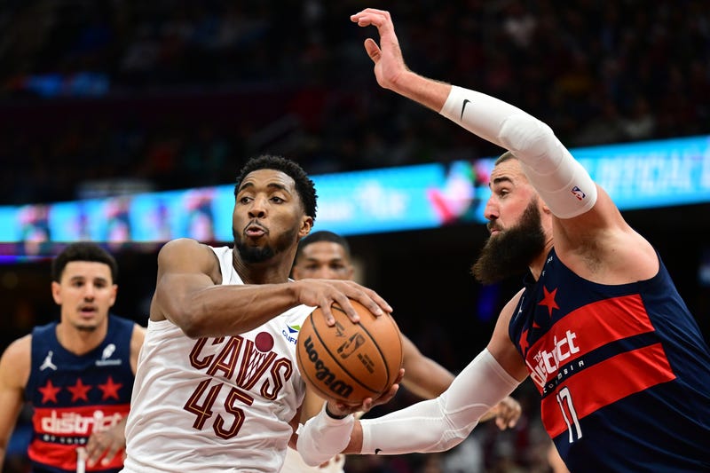 Dec 13, 2024; Cleveland, Ohio, USA; Cleveland Cavaliers guard Donovan Mitchell (45) passes as Washington Wizards center Jonas Valanciunas (17) defends during the second half at Rocket Mortgage FieldHouse.