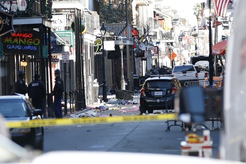 A view down Bourbon Street showing a crashed white pickup truck (R) after an apparent attack during New Year's Eve celebrations in New Orleans.