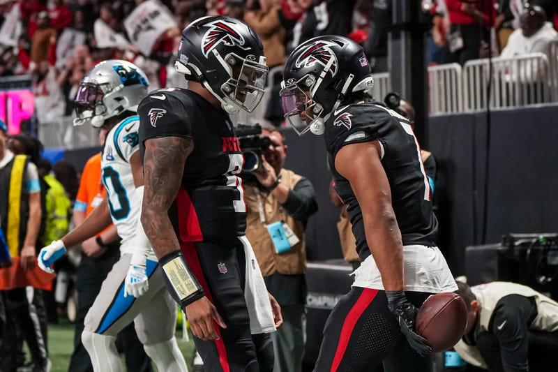 Atlanta Falcons running back Bijan Robinson (7) reacts with quarterback Michael Penix Jr. (9)